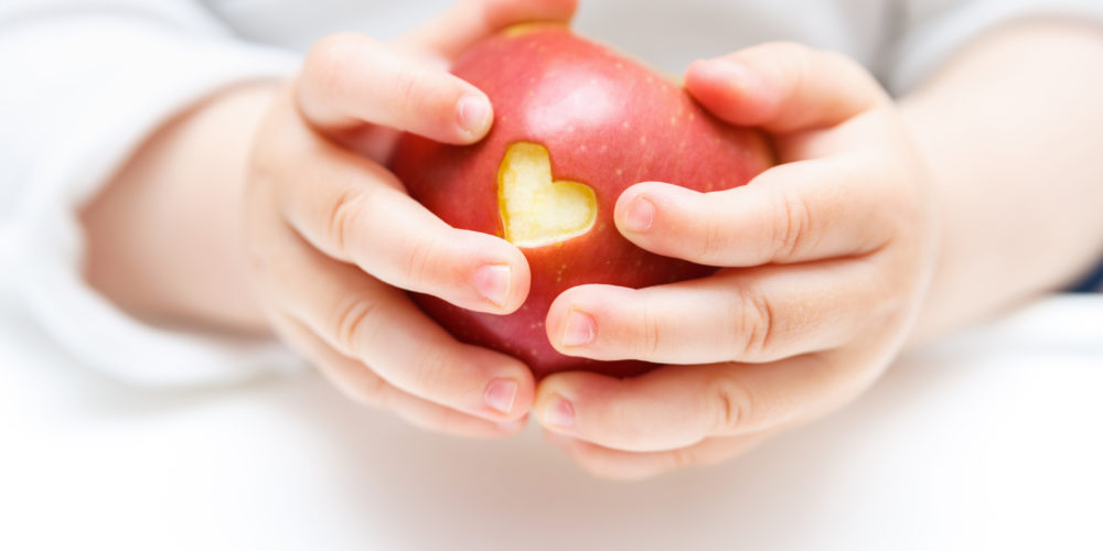 Baby hands with apple isolated on white Baby hands with apple isolated on white